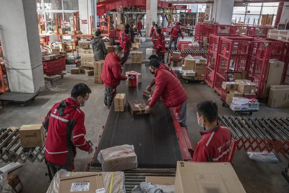 Centro de distribuição na China com equipe separando caixas na esteira